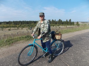 Быстро катит на велосипеде местный житель — держит путь в деревню Ежово.